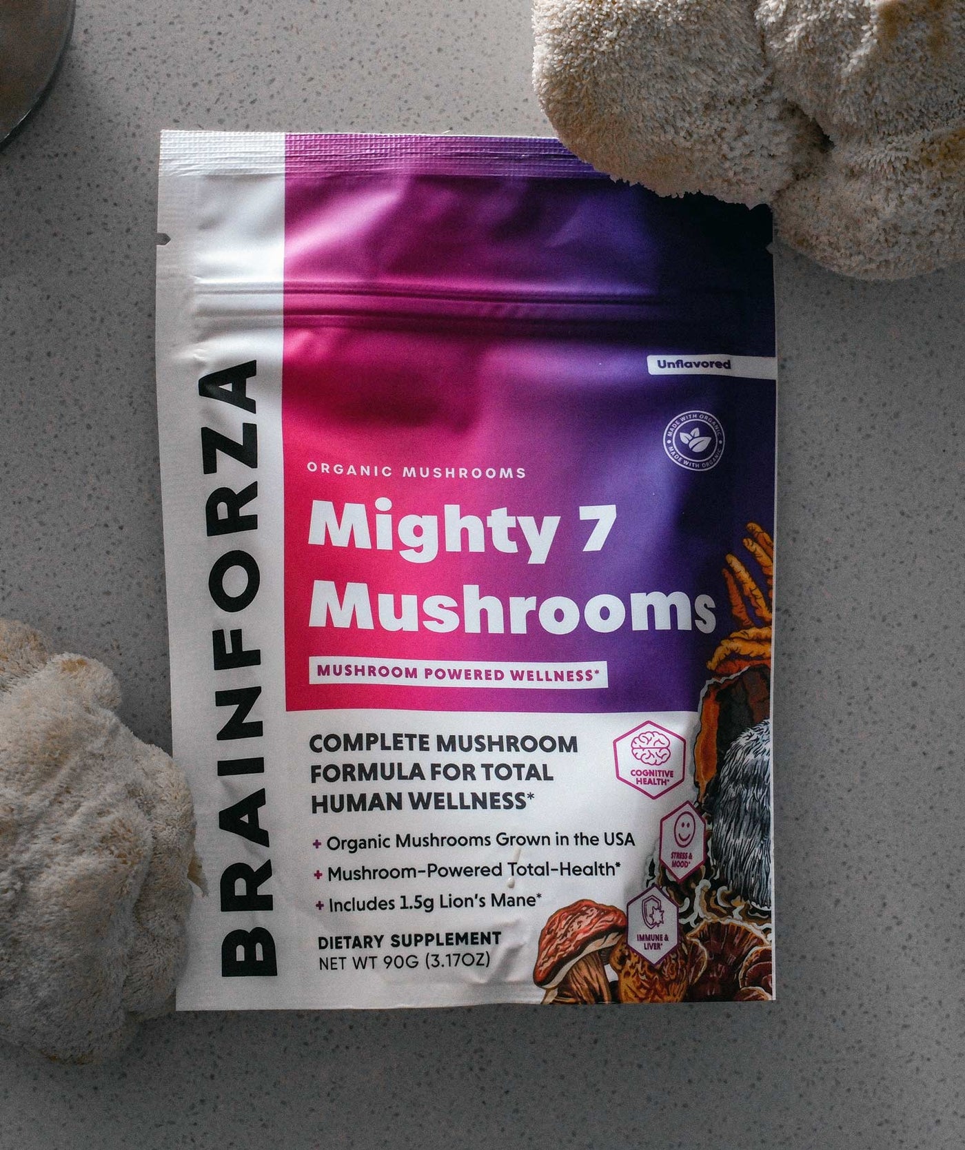 Package of BRAINFORZA Mighty 7 Mushrooms on a gray surface with mushrooms in the background


